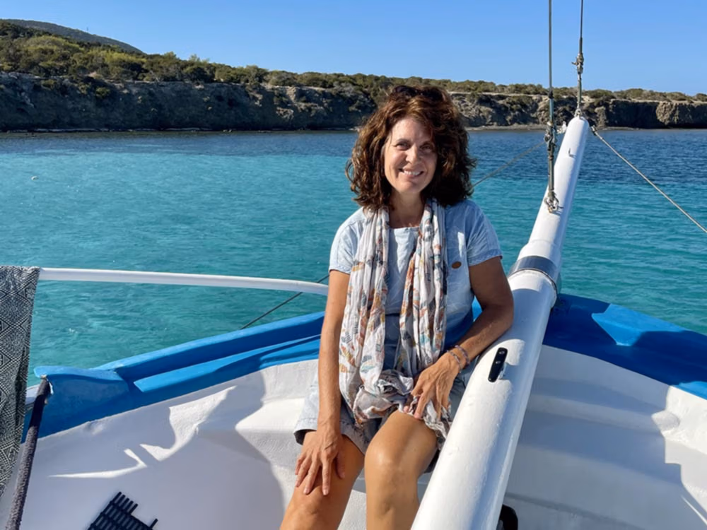 Marion Ancker, die Leitung vom offenen Yoga Programm auf Zypern sitzt auf einem Boot in der Blauen Lagune